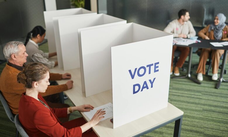 Person casting ballot in voting booth during election