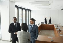 Professional business meeting with diverse team members discussing strategy around conference table