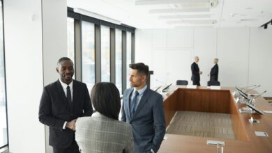 Professional business meeting with diverse team members discussing strategy around conference table