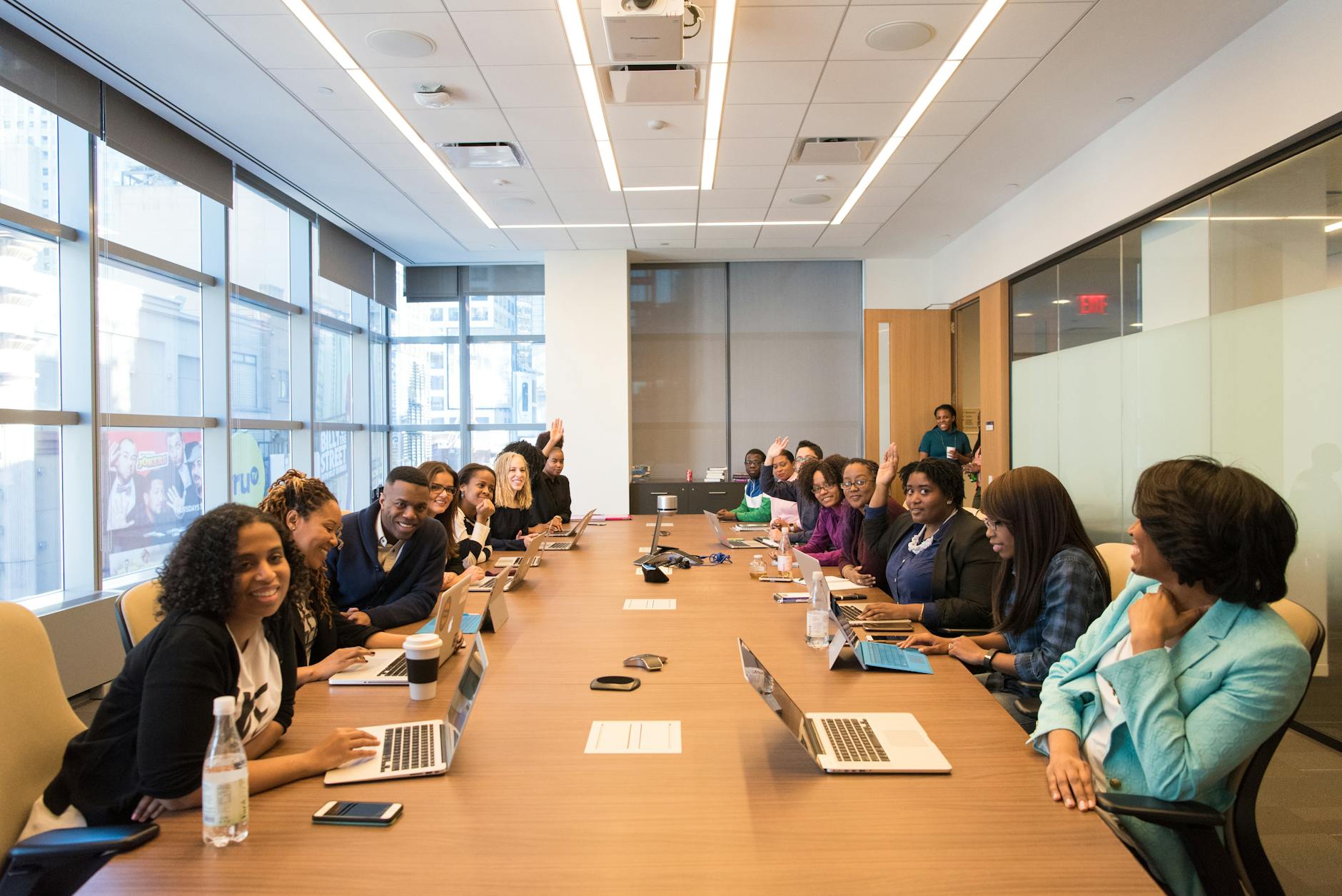 Professional meeting room with employees gathered around table during workplace presentation