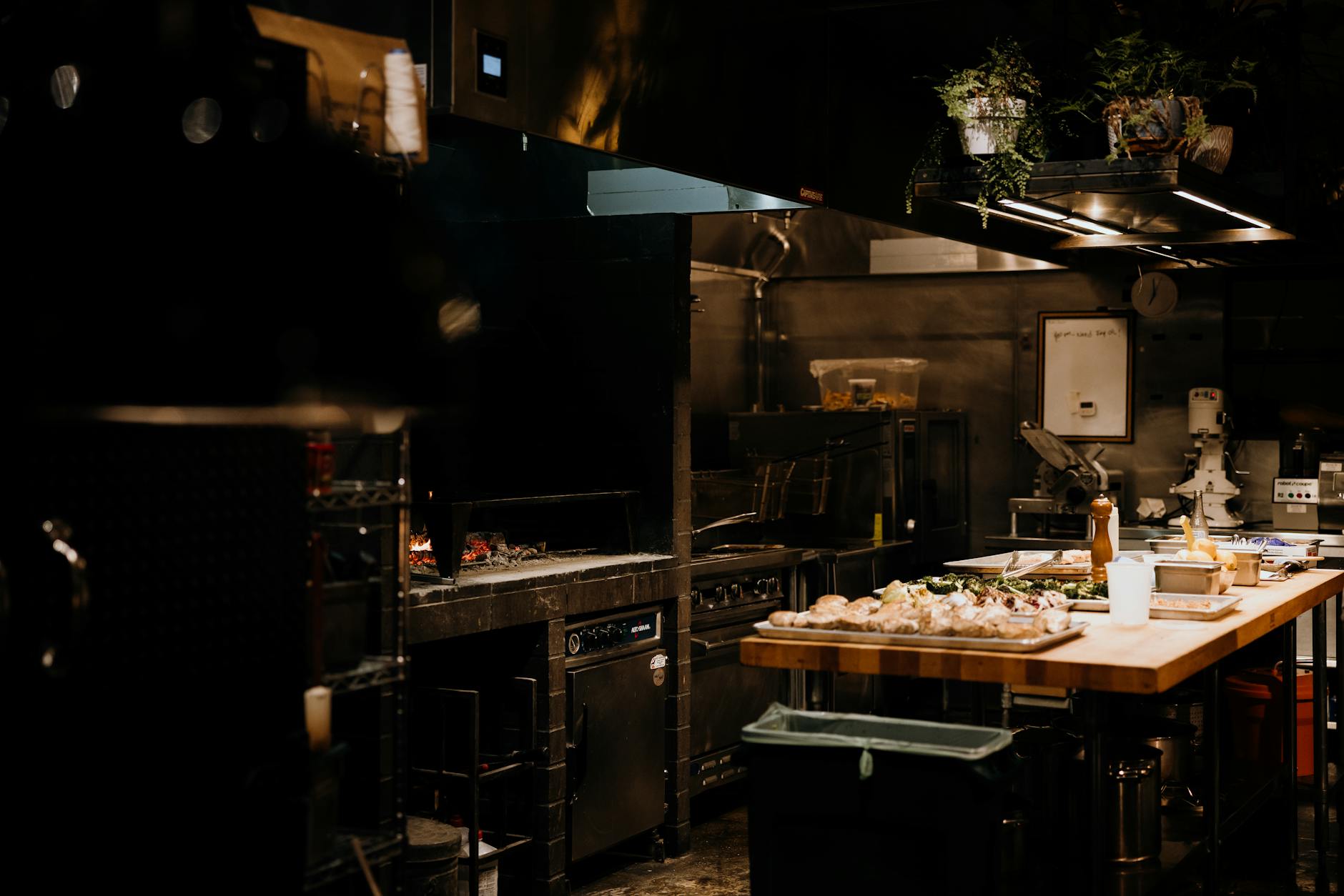 Modern commercial kitchen with stainless steel equipment and food preparation stations