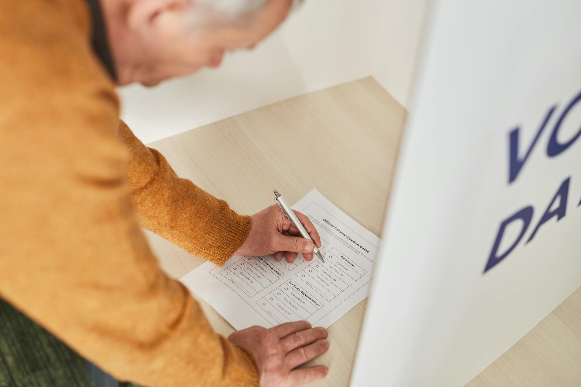 Person casting ballot at voting booth during election