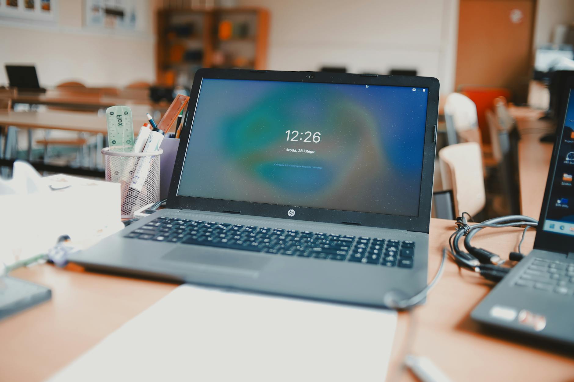 Laptop computer open in classroom setting showing remote learning technology interface