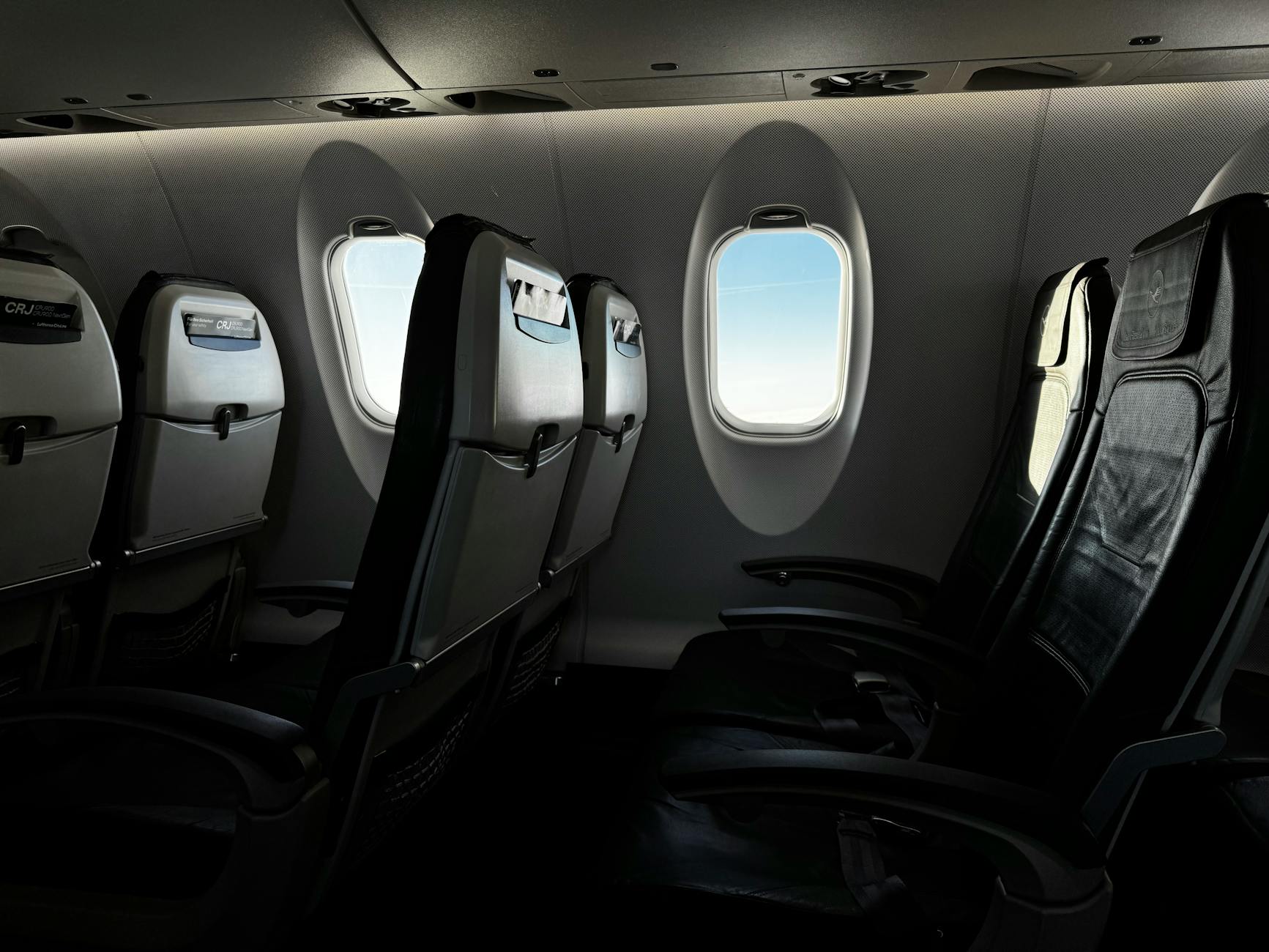Modern aircraft cabin interior showing business class seating configuration with comfortable leather seats