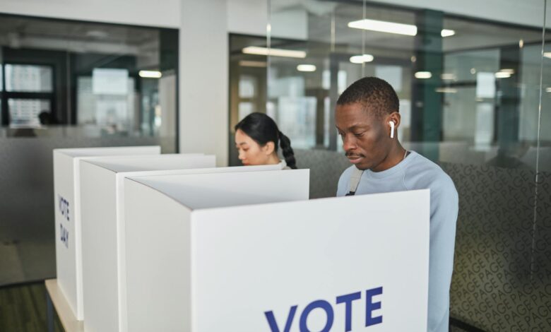 Person casting ballot in private voting booth during election