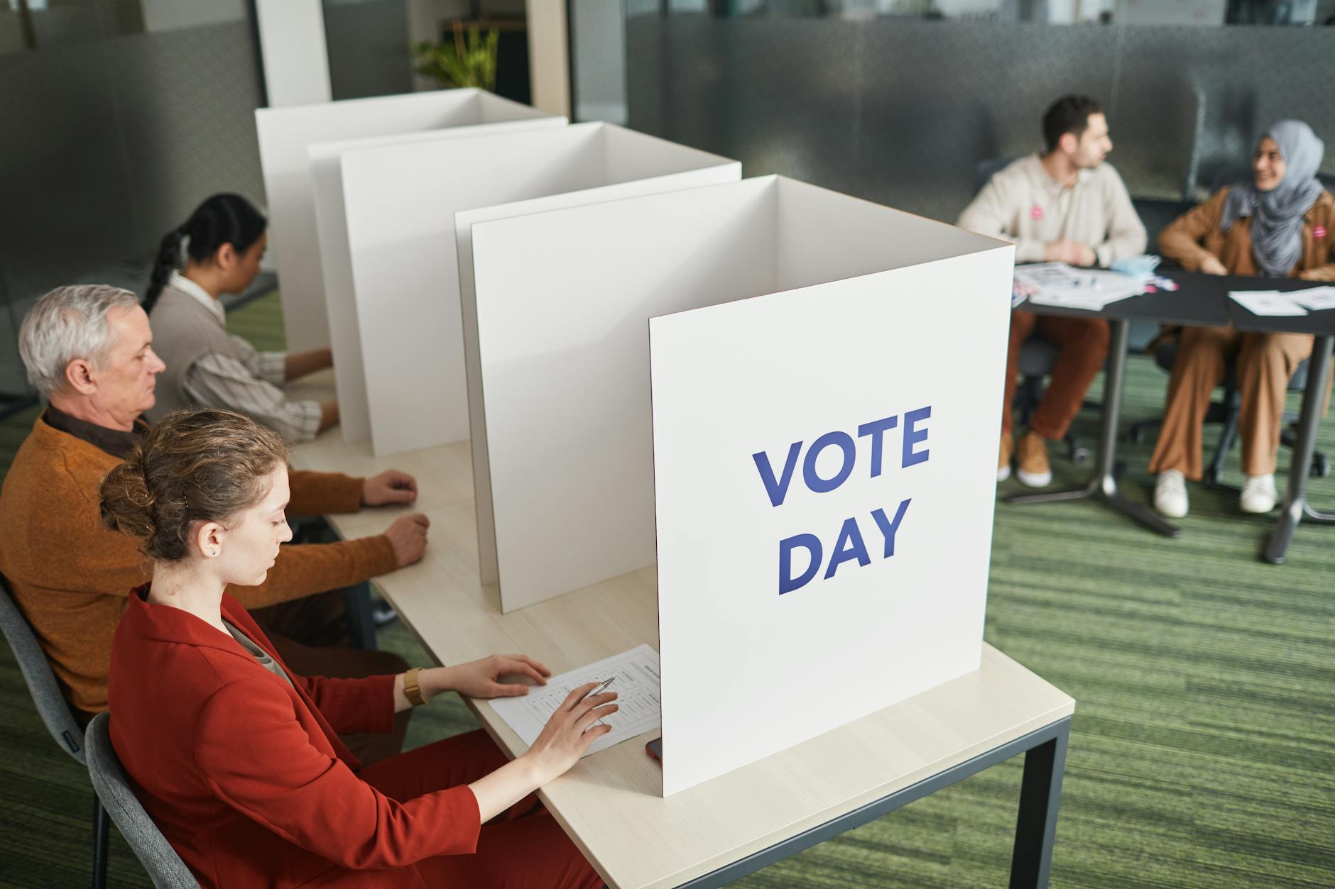 Person at voting booth representing democratic participation and electoral reform