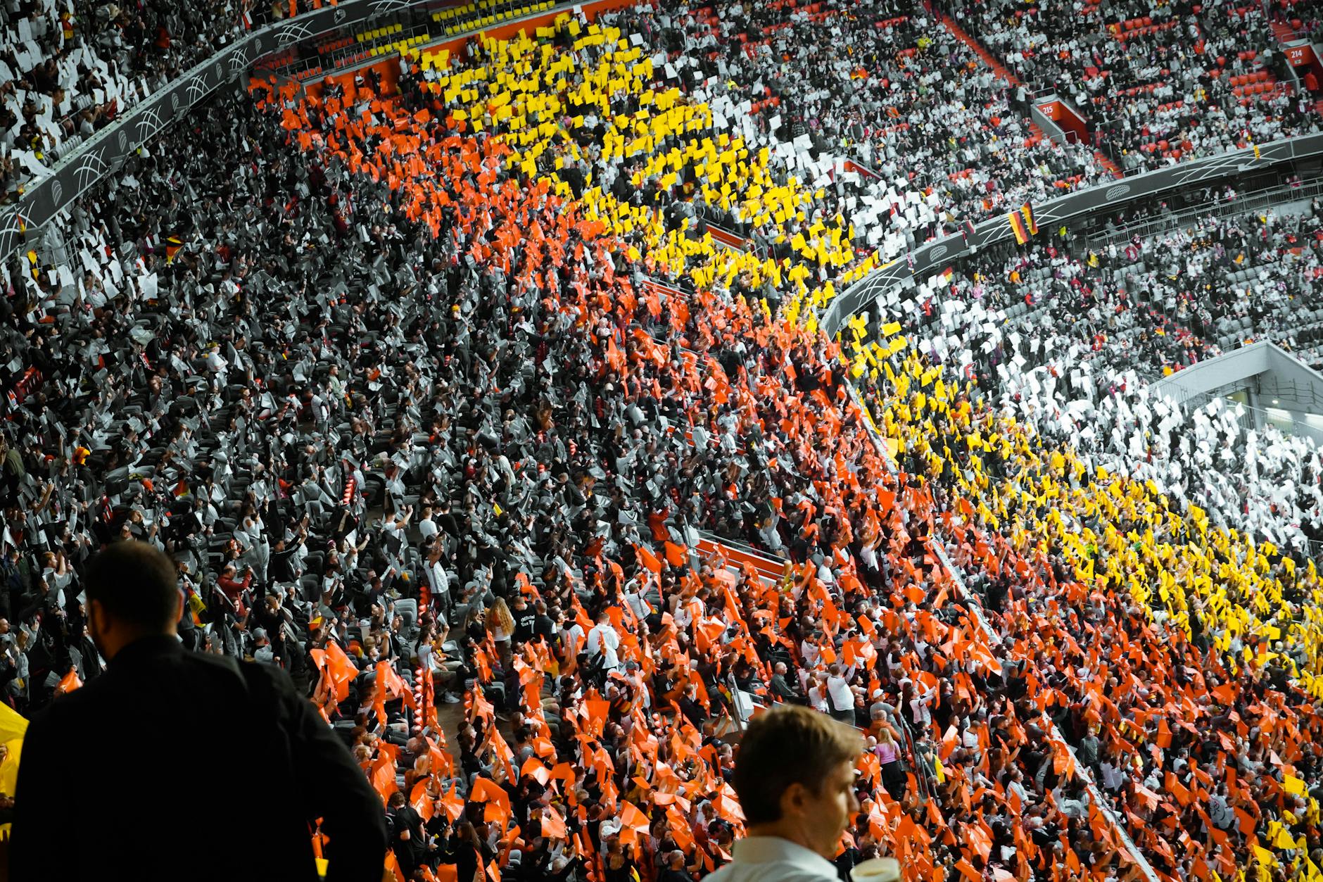 Large crowd of sports fans cheering in stadium during evening game