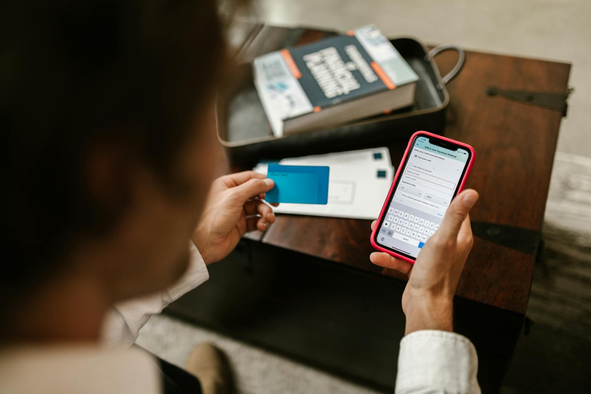 Person using smartphone to check banking app with financial charts and account information visible on screen