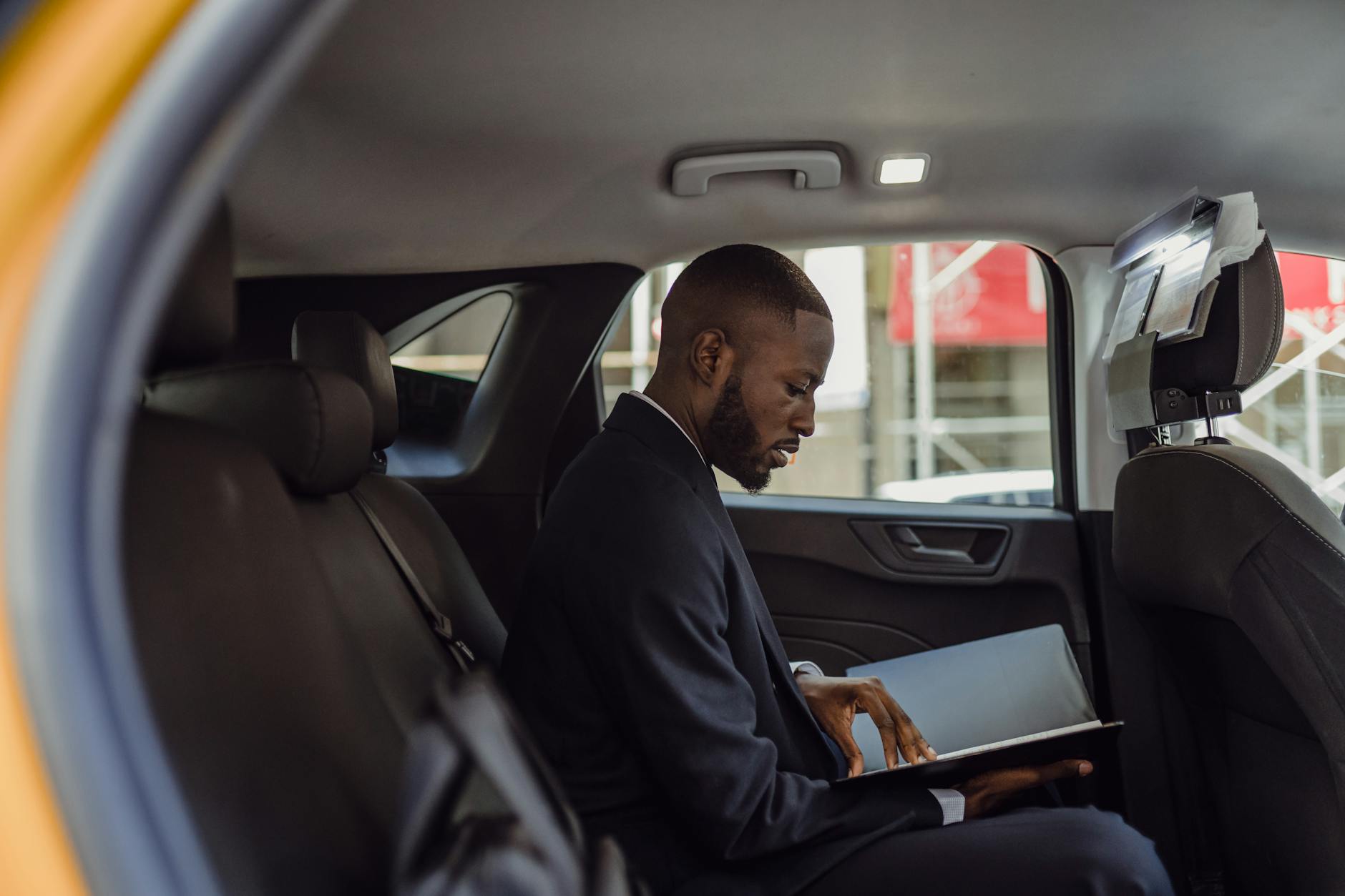 Professional business travelers working on laptops in comfortable airplane seats during flight