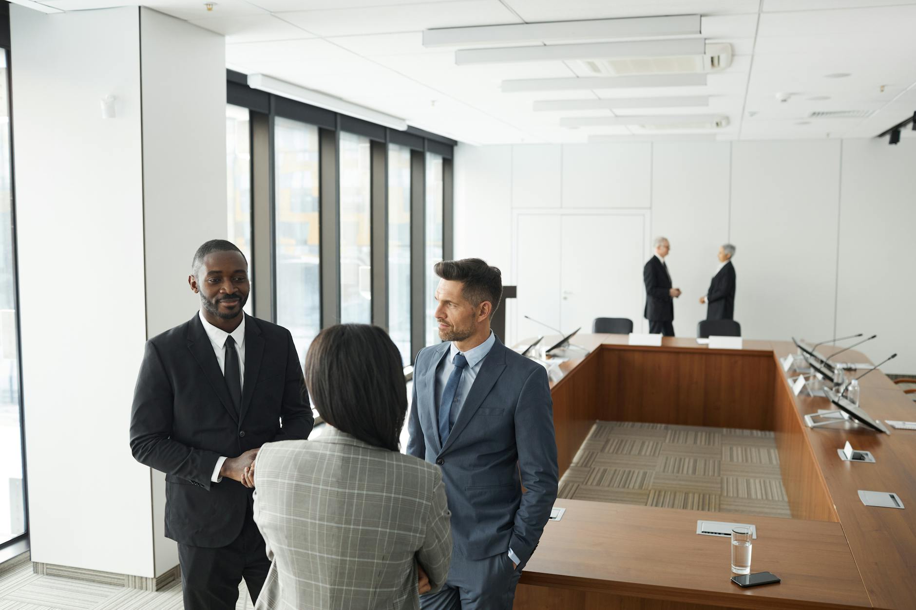 Banking executives discussing merger documents around conference table