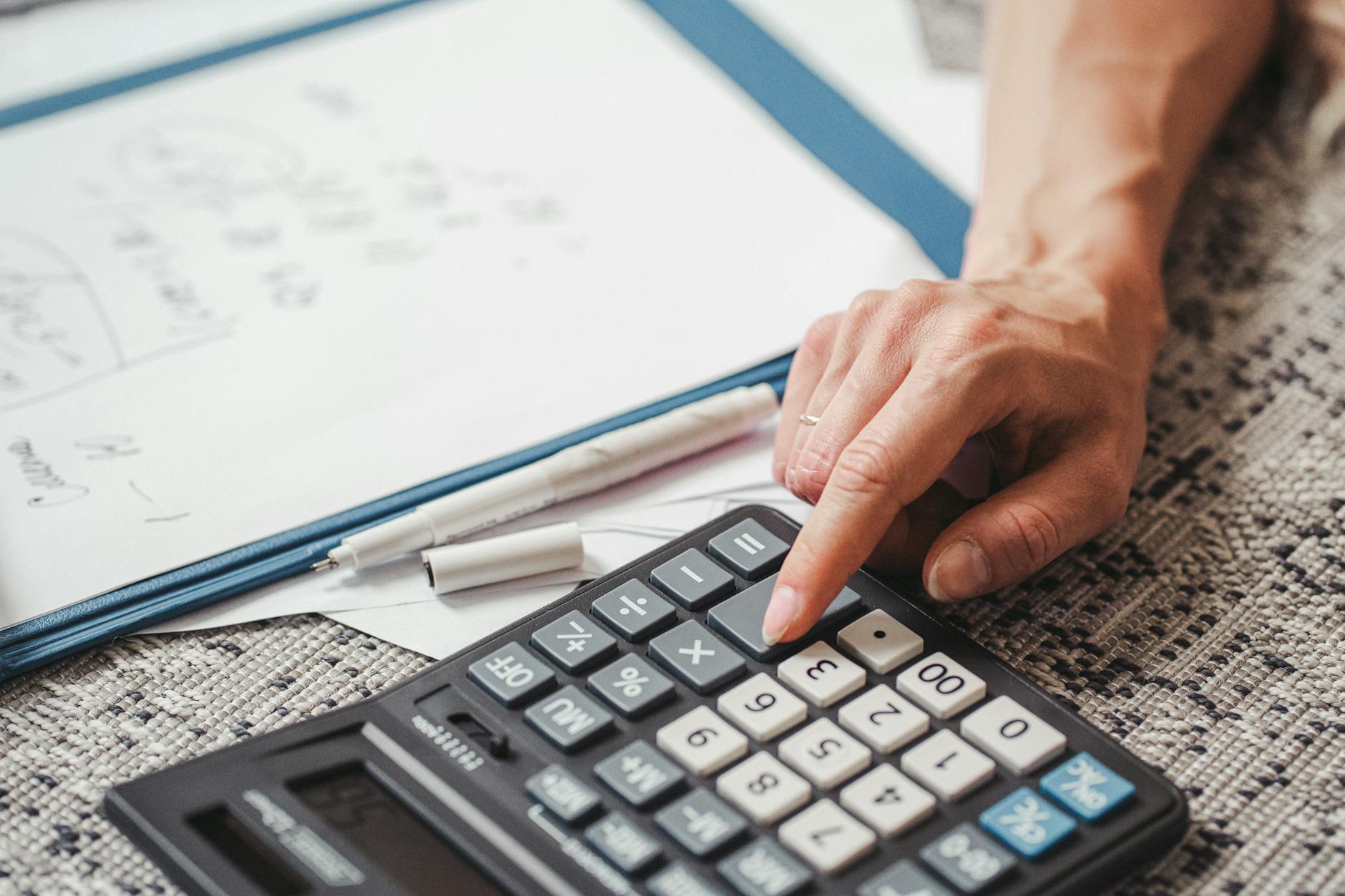 Business calculator and financial spreadsheets showing productivity calculations and metrics