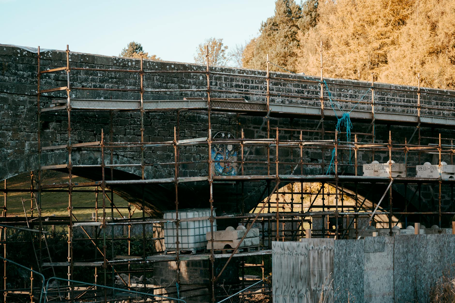 Workers maintaining and repairing bridge infrastructure with safety equipment