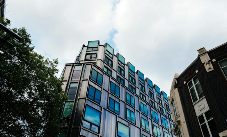 Glass office tower exterior reflecting sky, representing commercial real estate holdings