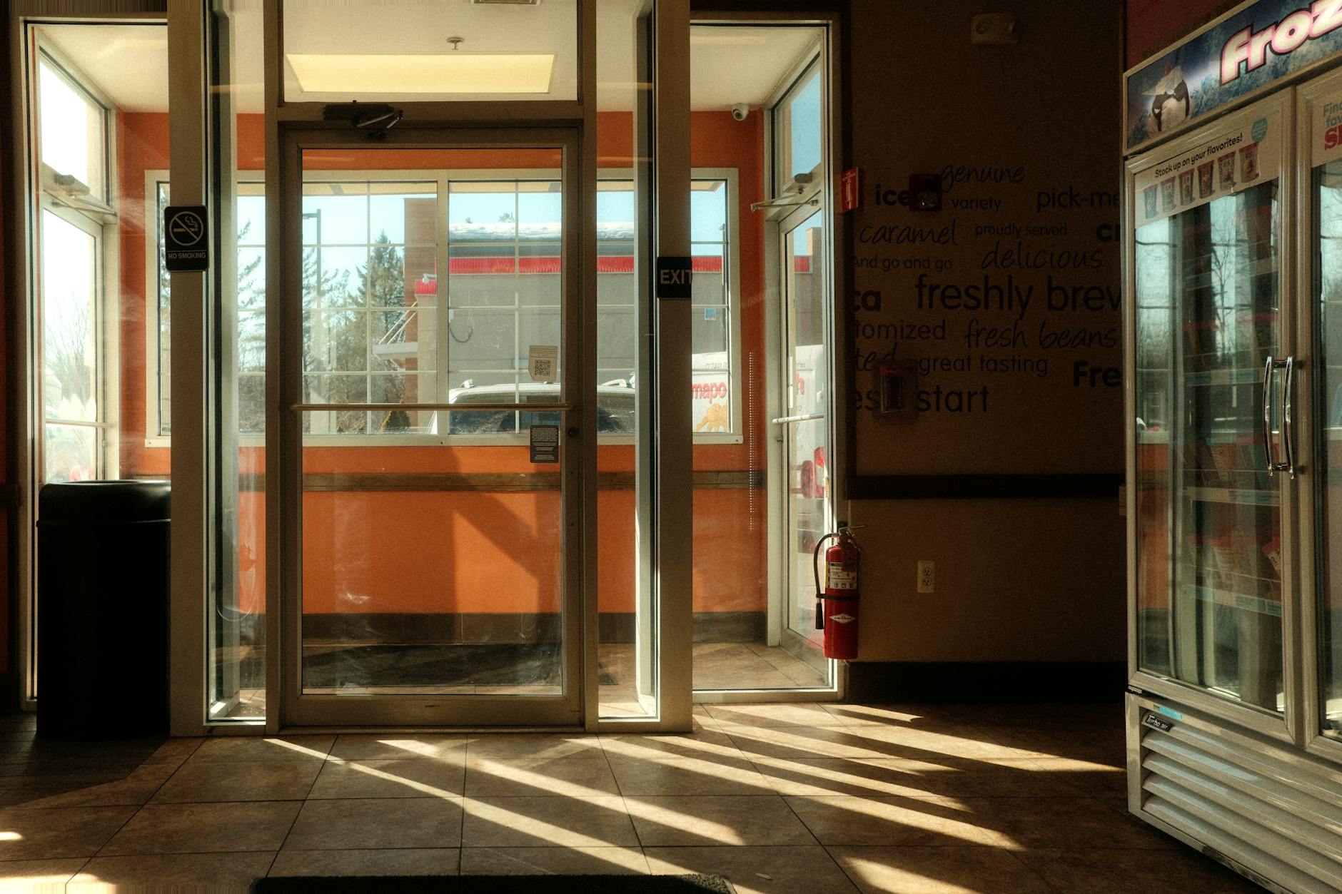 Modern convenience store interior with food service counter and refrigerated beverage section