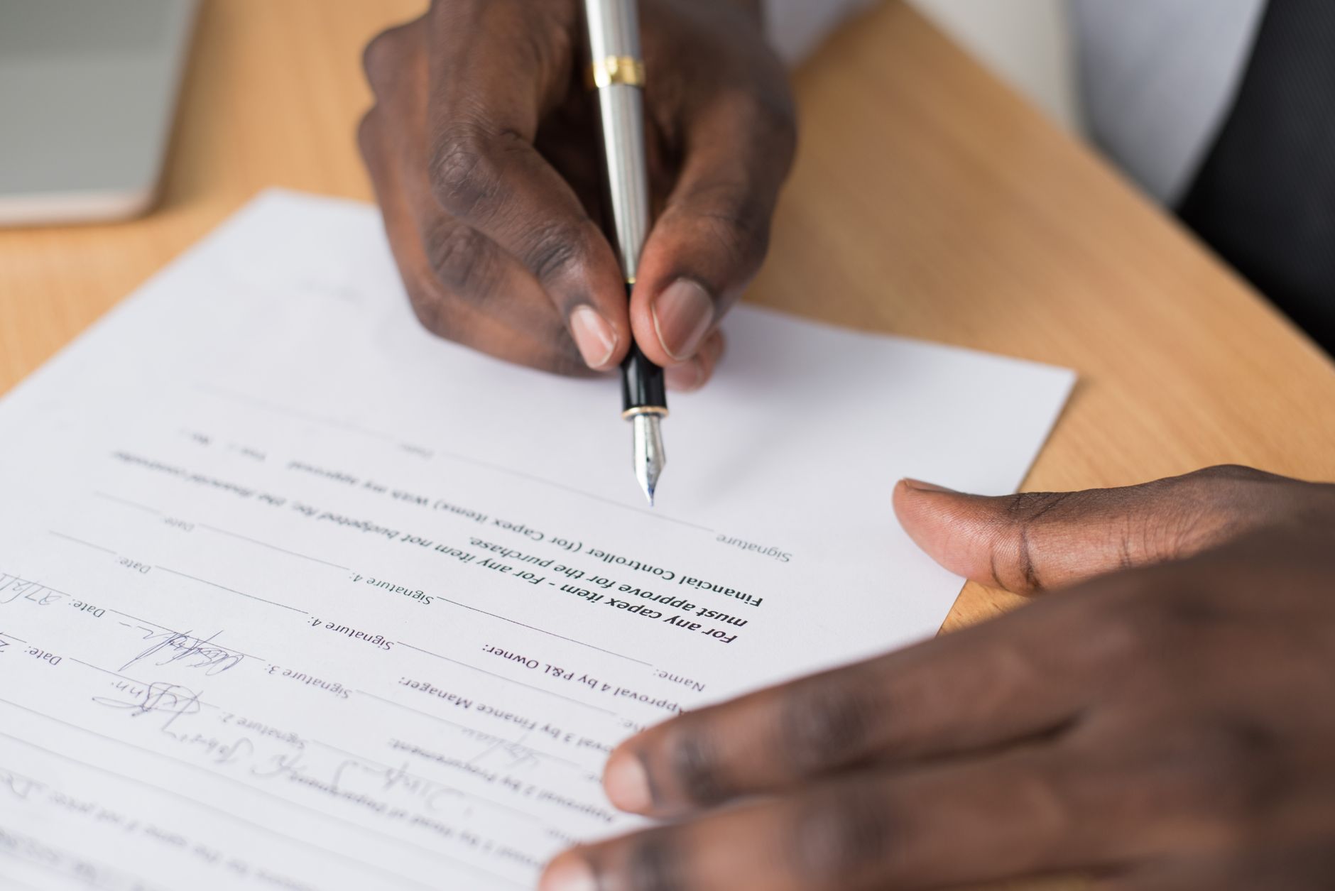 Two people reviewing and signing a business agreement at a desk