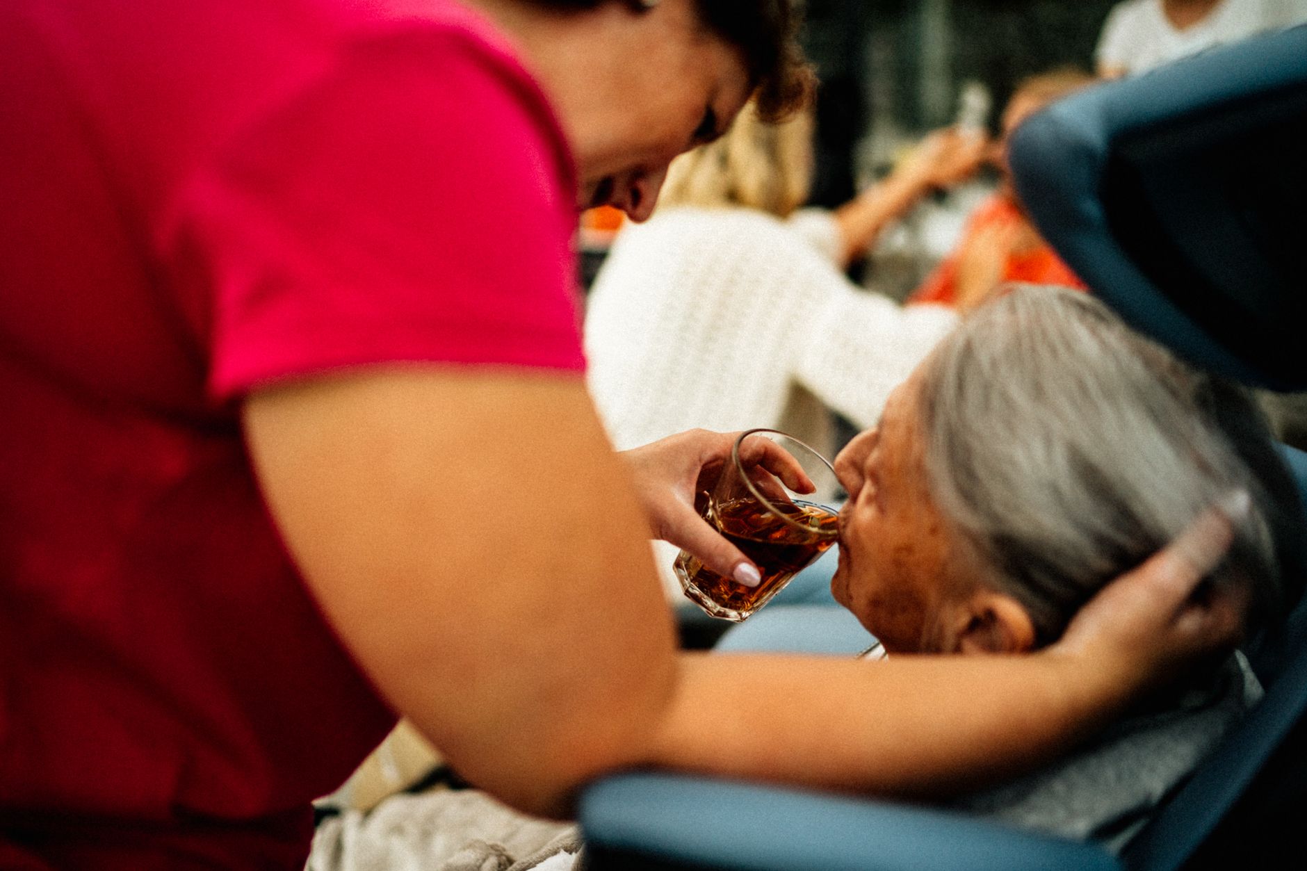 A healthcare worker attending to an elderly patient in a care setting