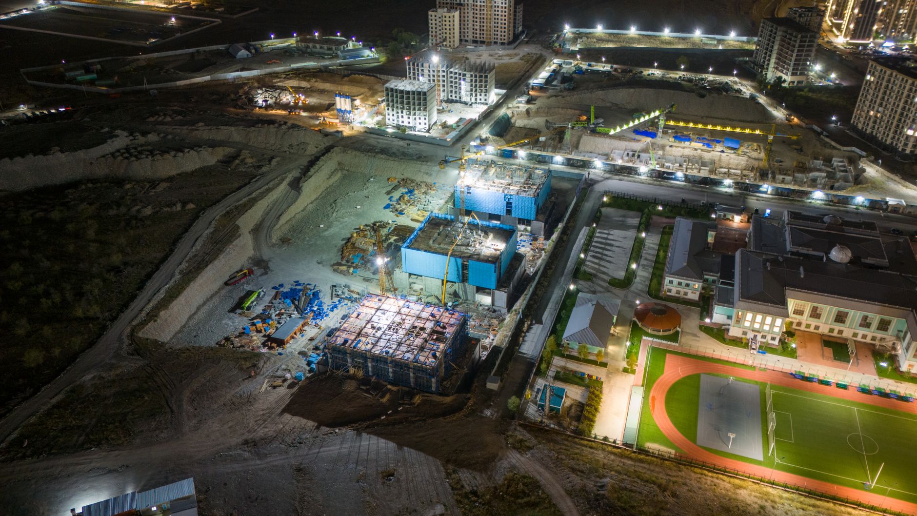 Aerial view of a commercial construction site with cranes and building frames