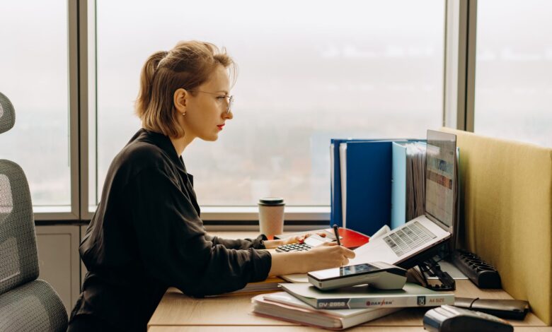 Accountant working at a desk with financial documents and a laptop