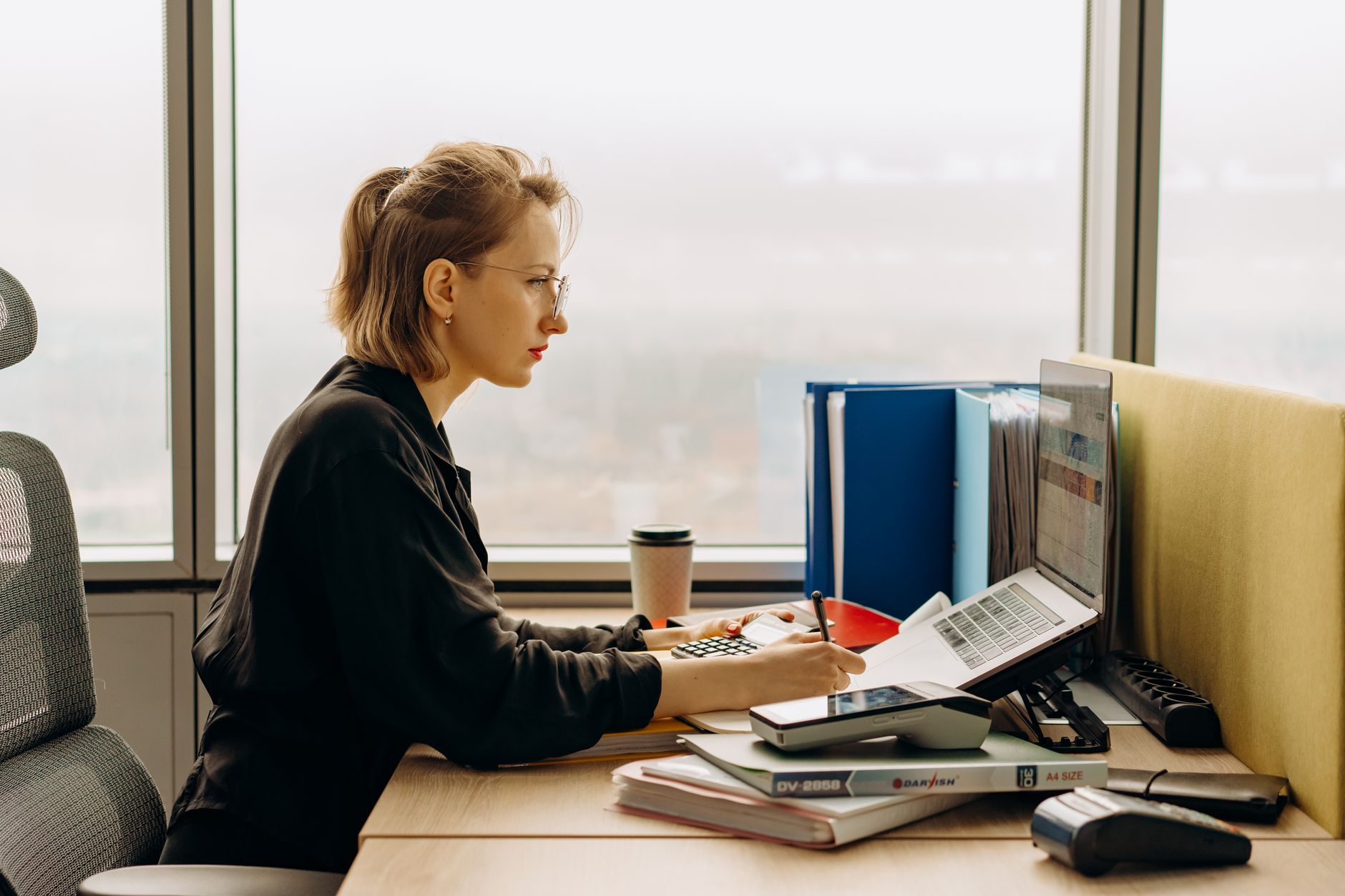 Accountant working at a desk with financial documents and a laptop