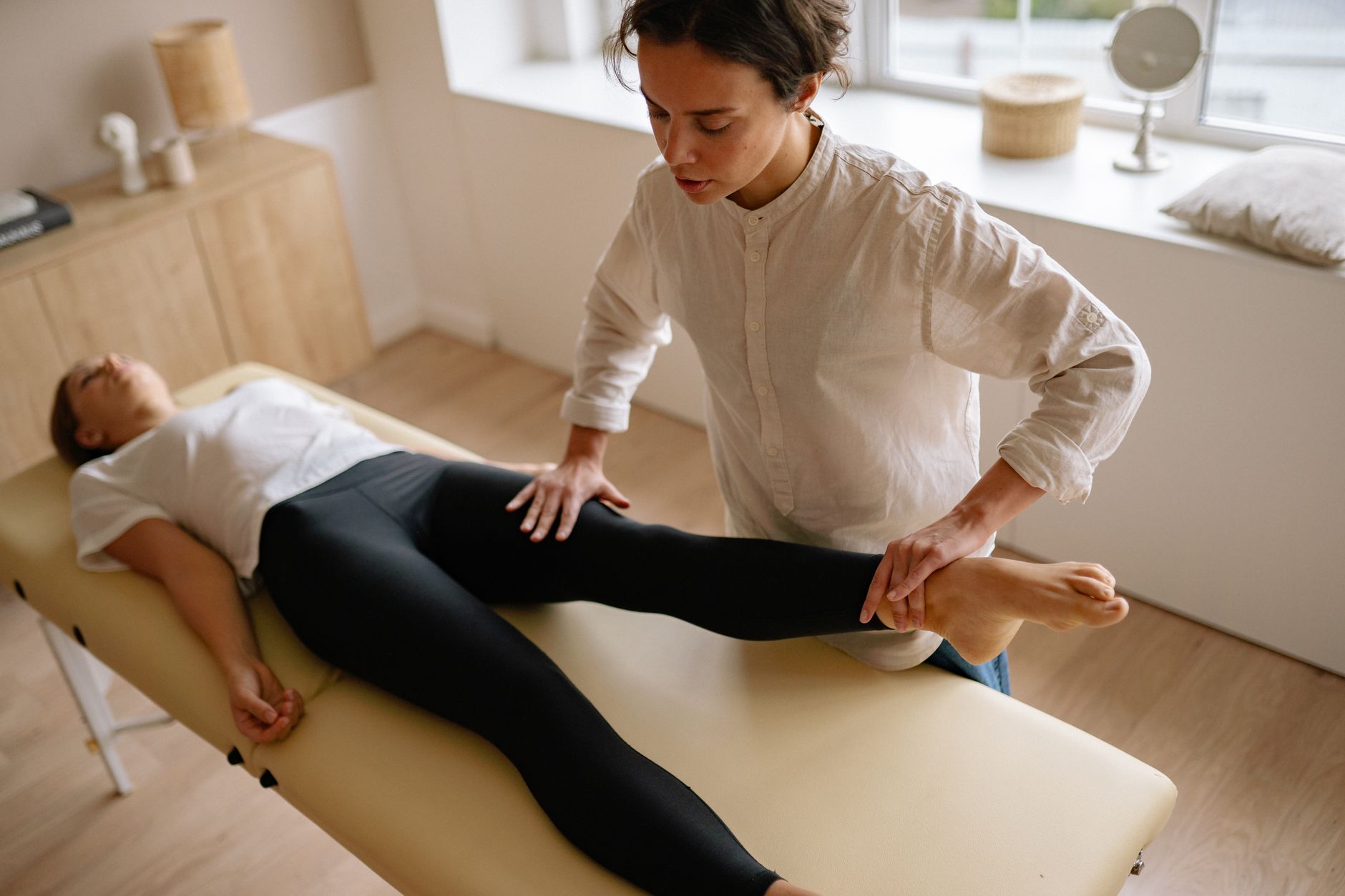 A physical therapist working with a patient in a clinical rehabilitation setting