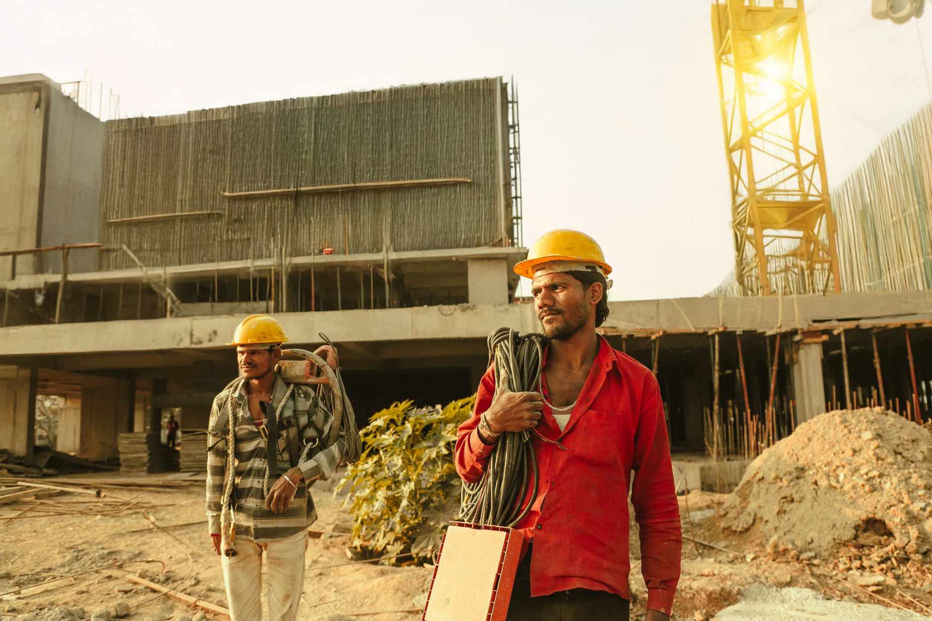 Construction workers on an active job site wearing safety helmets and vests