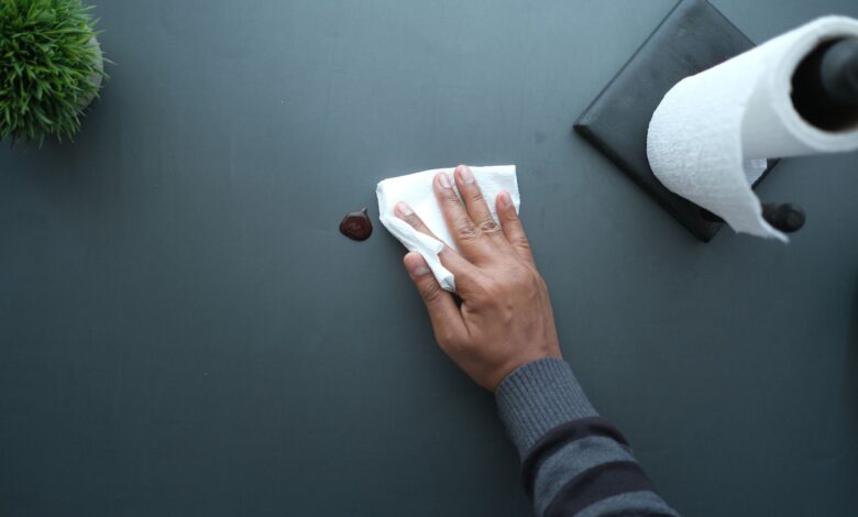 Commercial cleaner wiping down an office desk in a modern workspace
