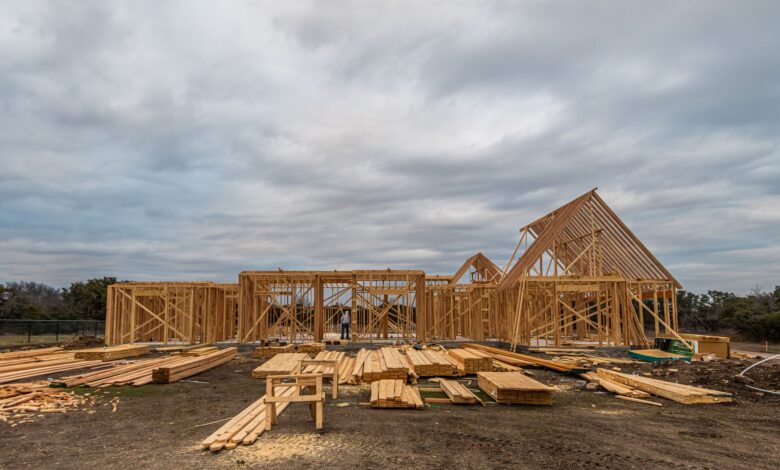 Aerial view of a residential construction site with framed homes and cleared land