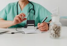 A healthcare billing professional reviewing insurance claims at a desk with multiple monitors