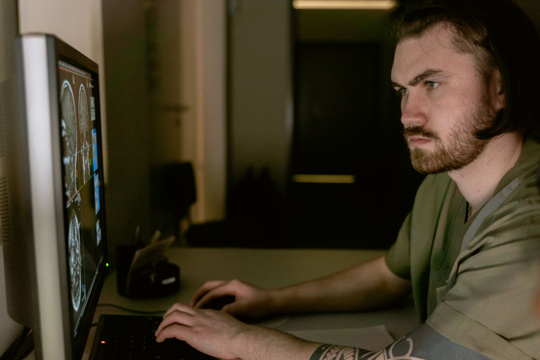 A radiologist reviewing medical imaging scans on a large diagnostic monitor