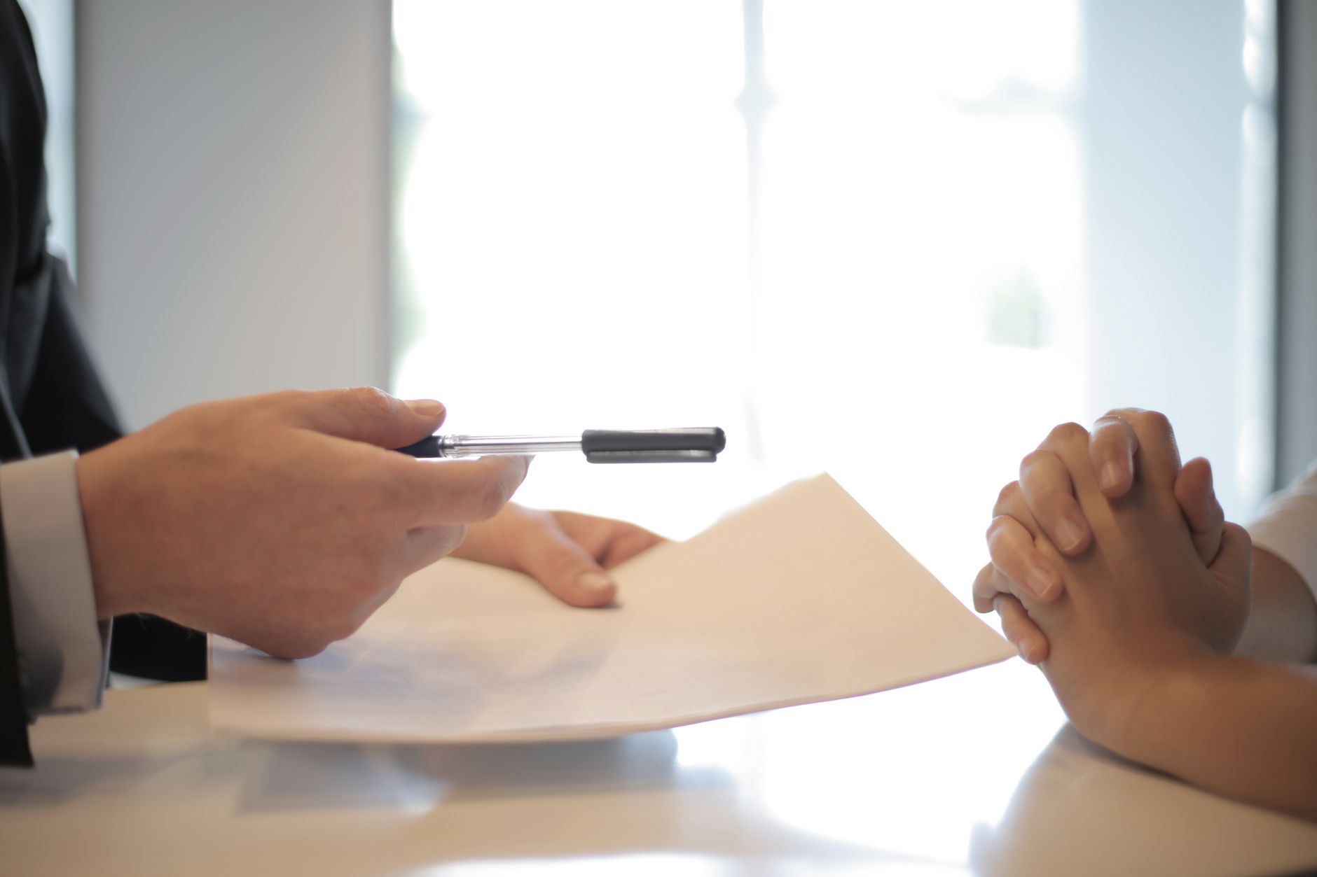 Business professional reviewing and signing insurance or legal documents at a desk