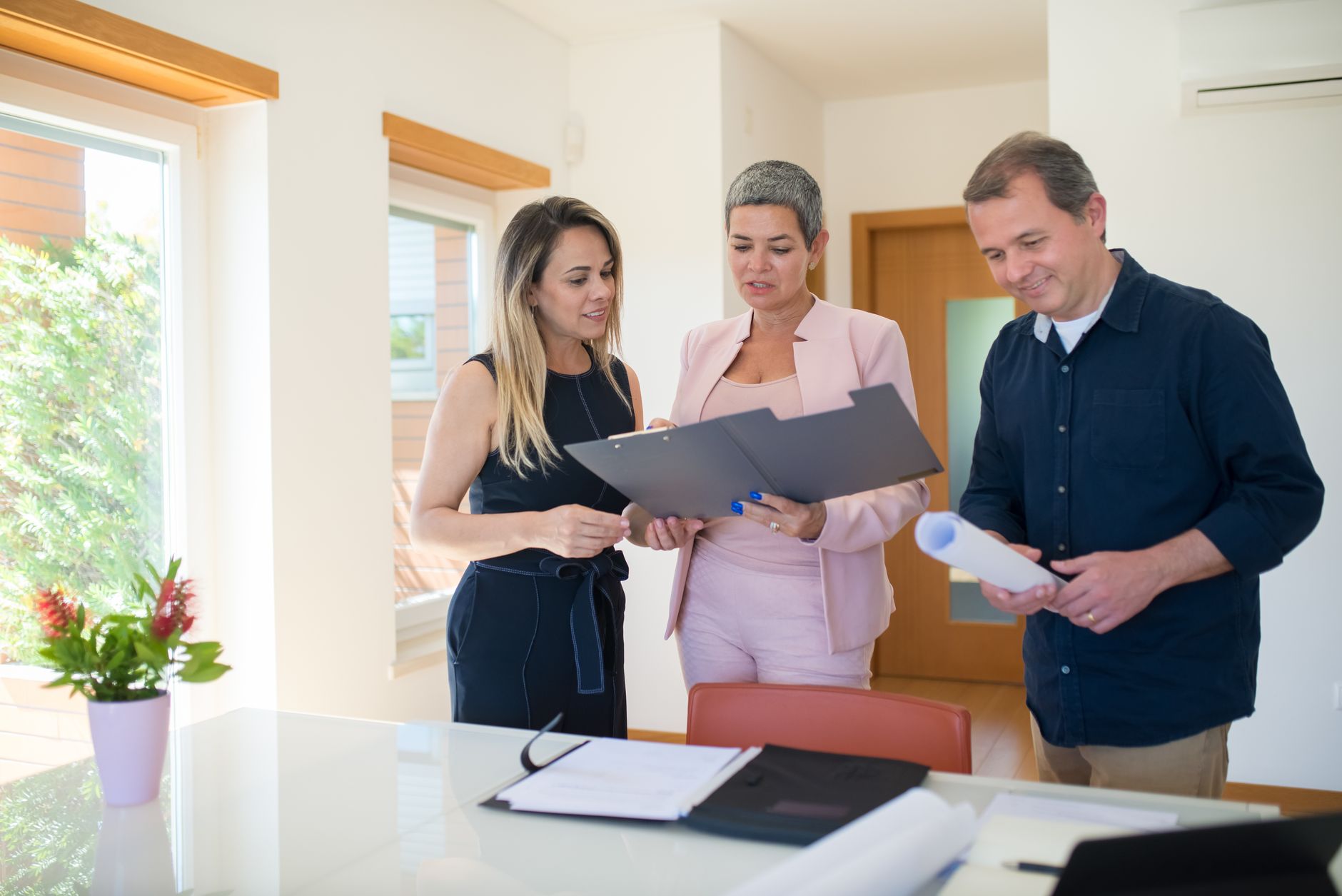 Business professionals reviewing documents at a table during a real estate transaction meeting