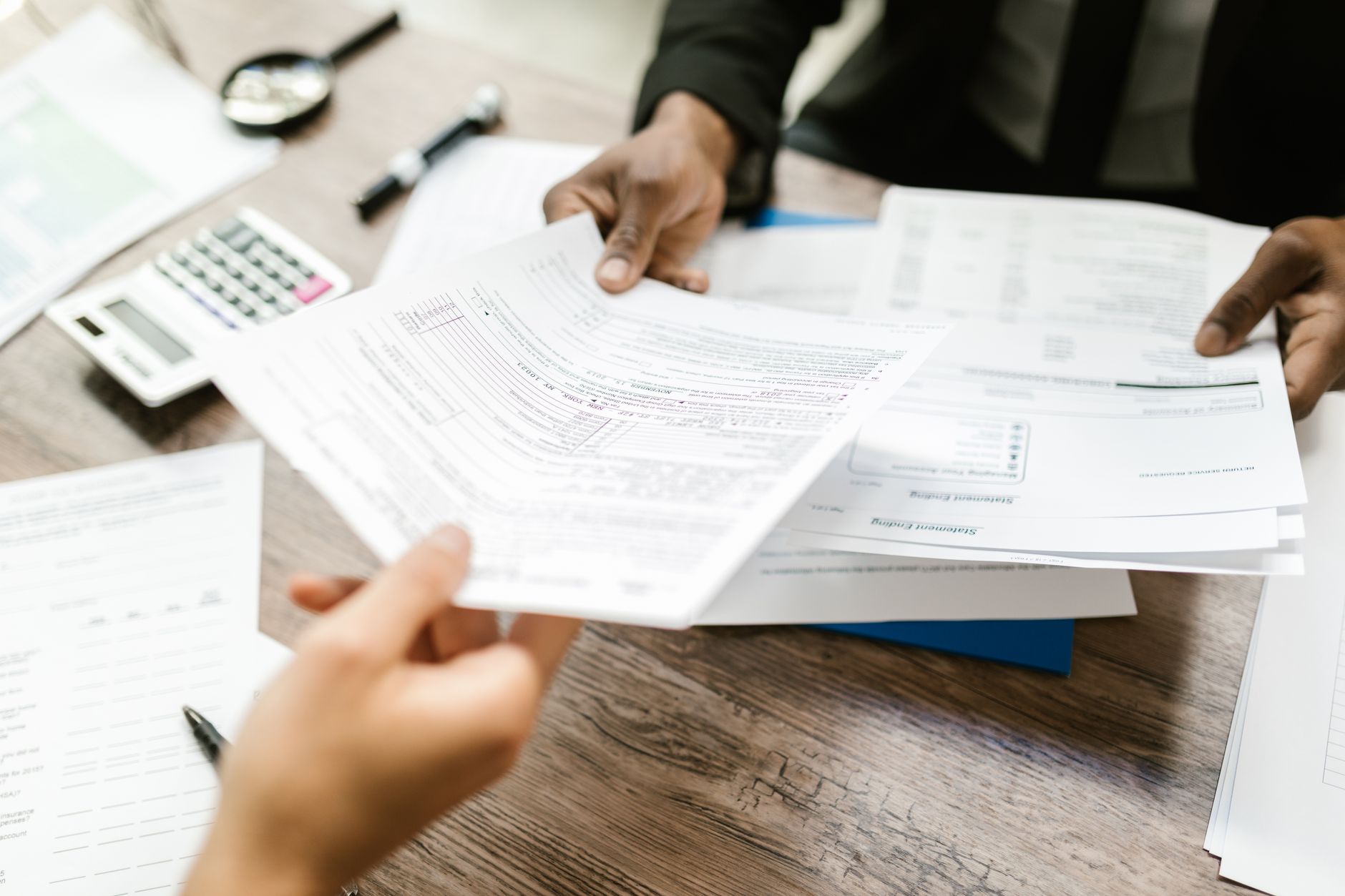 Business documents and contract paperwork spread across an office desk