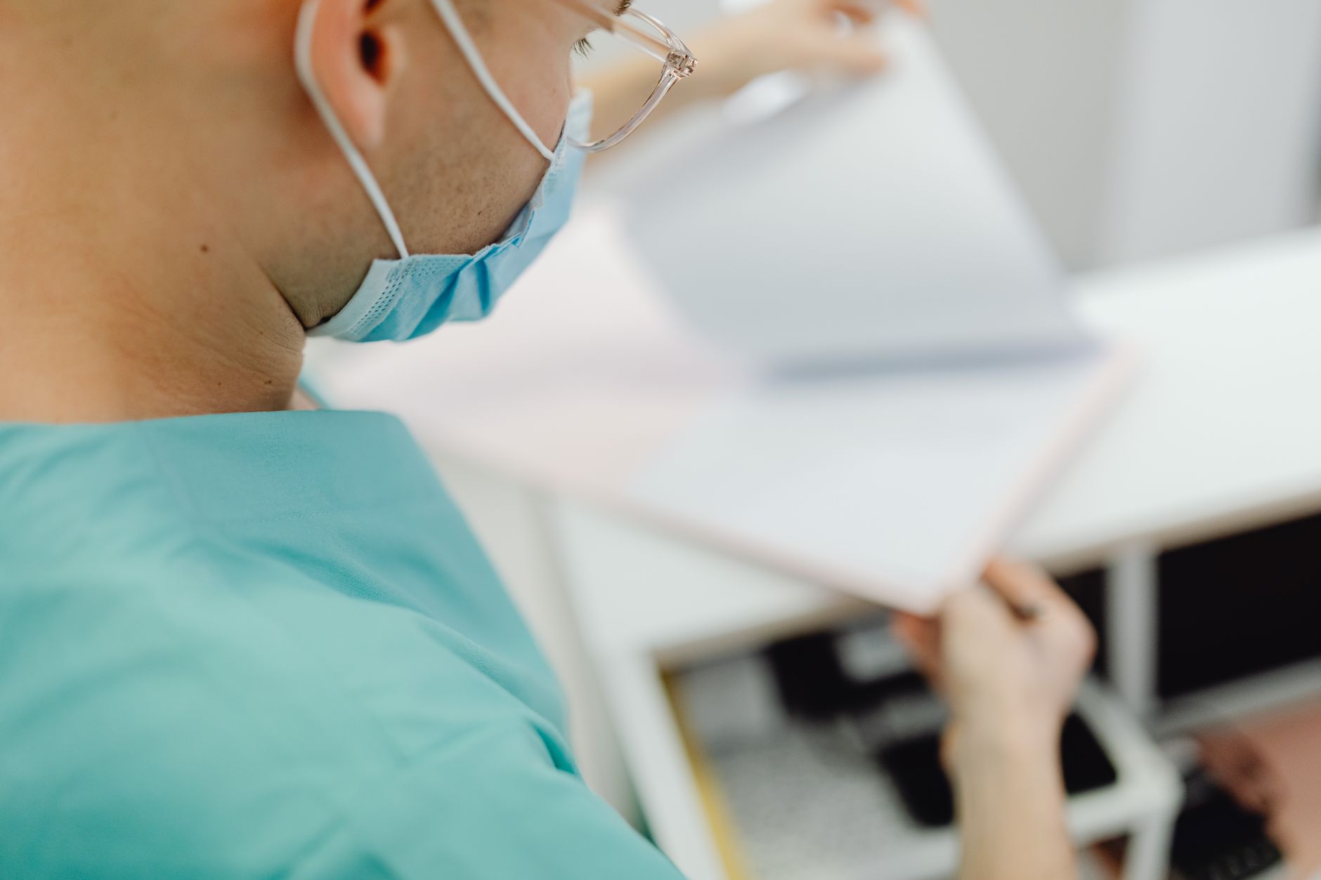 Physician reviewing and signing a contract at a desk
