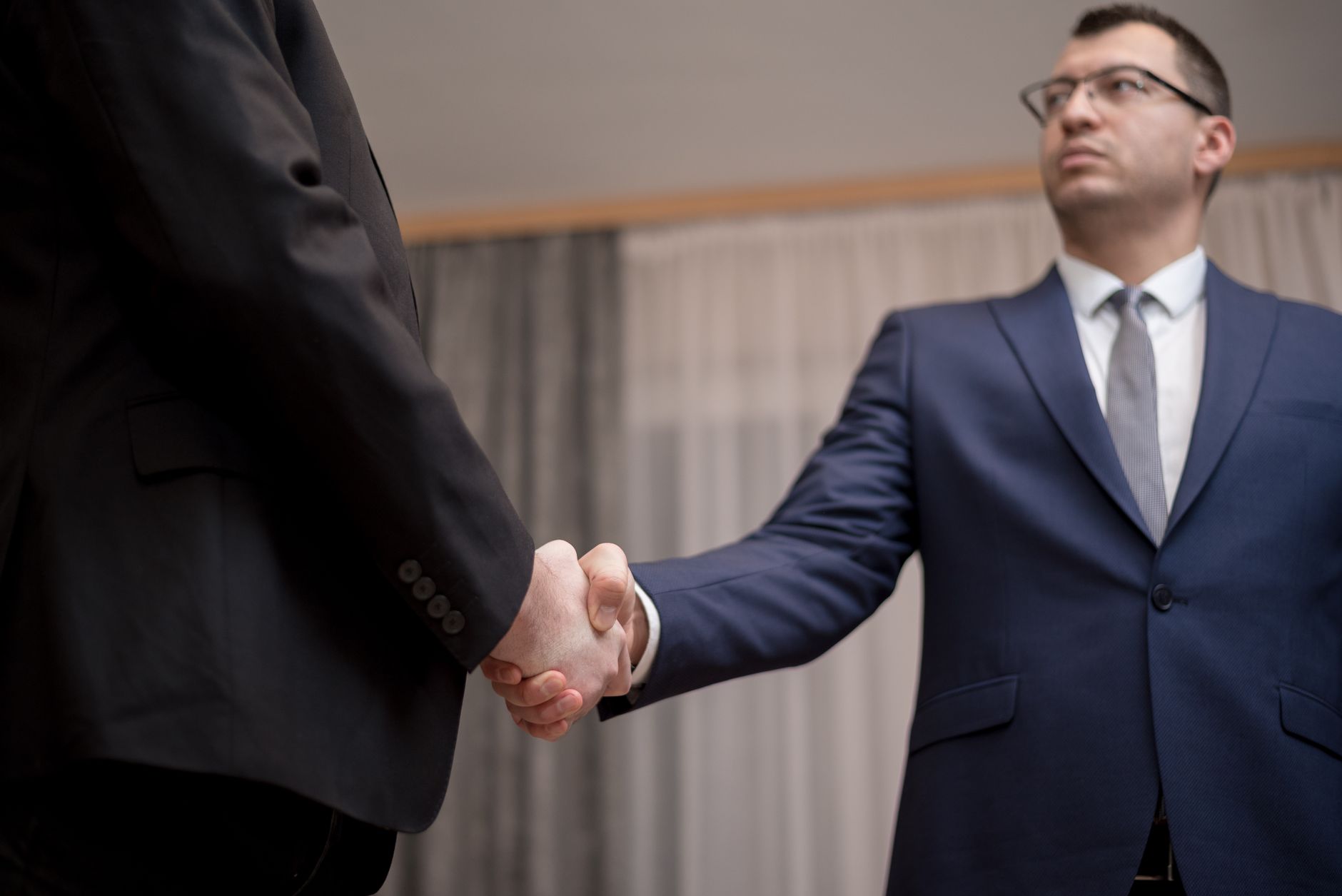 Two business professionals shaking hands representing a corporate acquisition deal