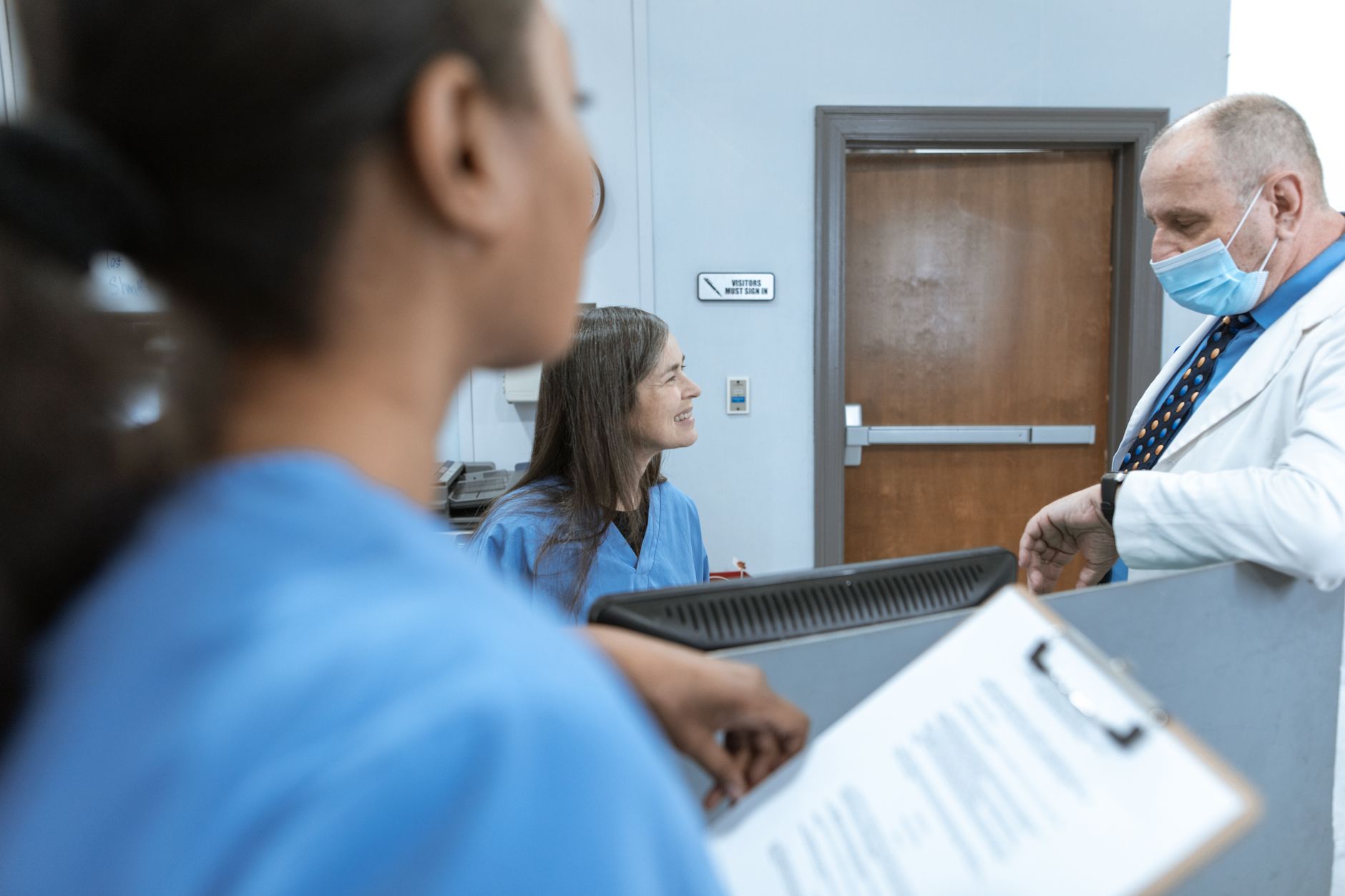 Healthcare professionals discussing documents at a conference table in a medical office