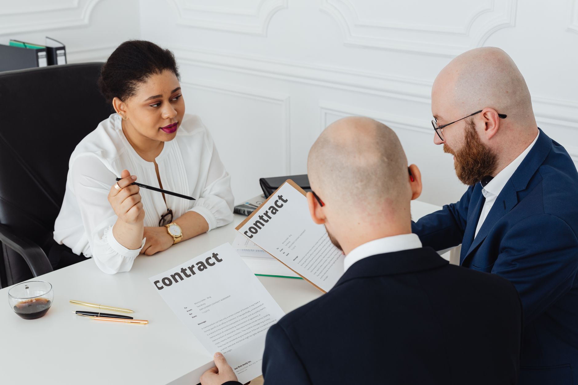 Two professionals reviewing and signing a business contract at a conference table