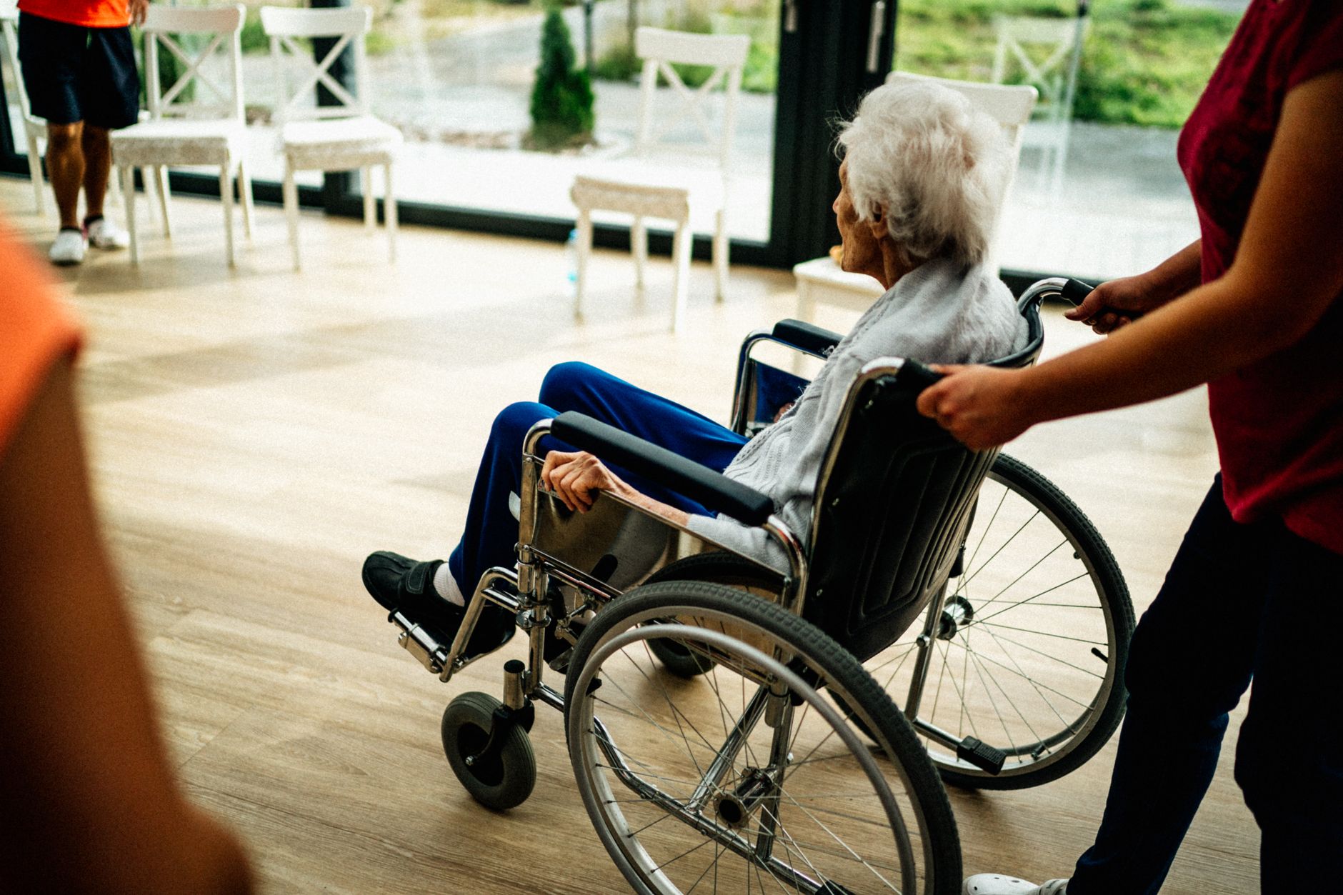 An elderly patient receiving care at home from a visiting nurse