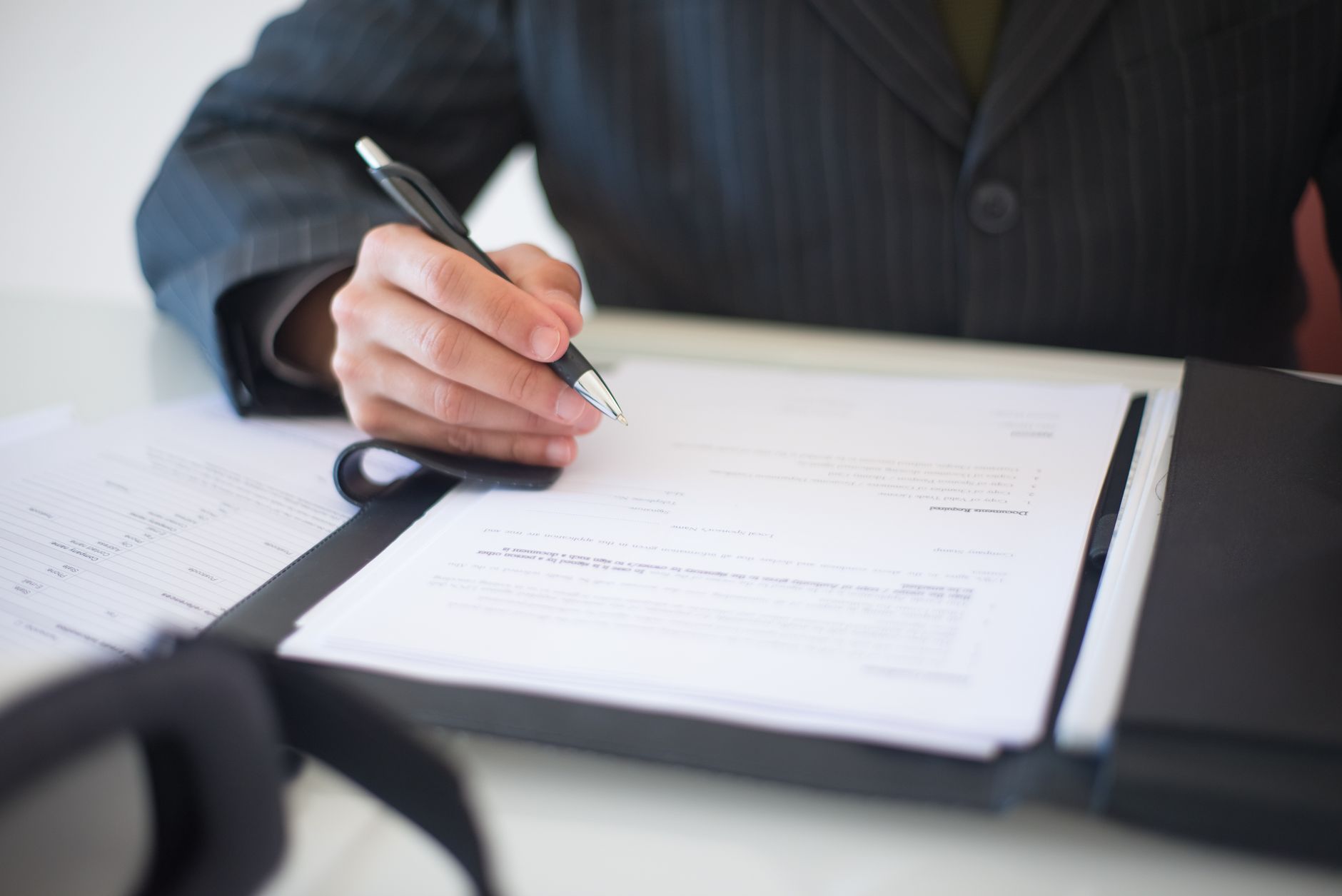 Business documents and contracts spread across a desk during a corporate meeting